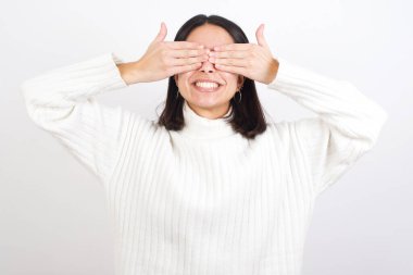 Gülümseyen neşeli ve komik ellerle gözlerini kapayan genç bir kadın. Kör kavram.