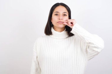 Genç kadın ağzı ve dudakları parmaklarıyla fermuar gibi kapalı. Gizli ve sessiz, tabu konuşması.