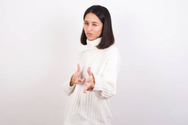 Neşeli genç bir kadın kameraya işaret parmağıyla göz kırpar, birini seçer, parmak tabancası yapar..