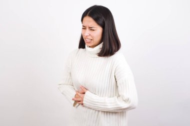 Mide bulantısı, acı veren hastalıklar yüzünden eli karnında olan genç bir kadın. Ache kavramı.