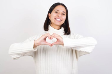 Elleriyle kalp sembolü yapan aşık bir genç kadın. Romantik konsept.