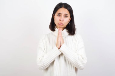 Olumlu genç bir kadın mutlu bir şekilde gülümser. Müdahaleciden hoş haberler aldığına sevinir. Avuç içlerini bir arada tutar..