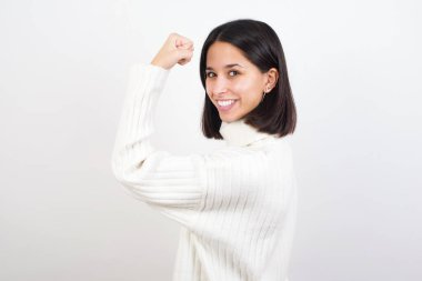 Kaslarını gösteren güçlü, neşeli genç bir kadının portresi..