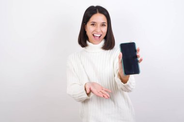 Cep telefonu olan genç bir kadın. Akıllı telefonu sunuyorum. Reklam kavramı.