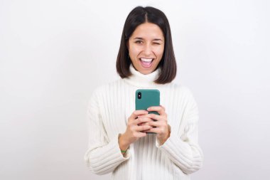 Genç bir kadın başarıyı kutlarken selfie çekiyor.