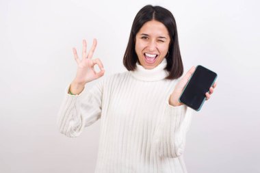 Hücrede el ele tutuşan genç bir kadın tamam işareti gösteriyor.