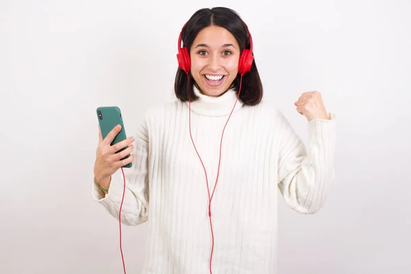 Jovem Mulher Positiva Detém Telefone Celular Moderno Conectado Fones Ouvido — Fotografia de Stock