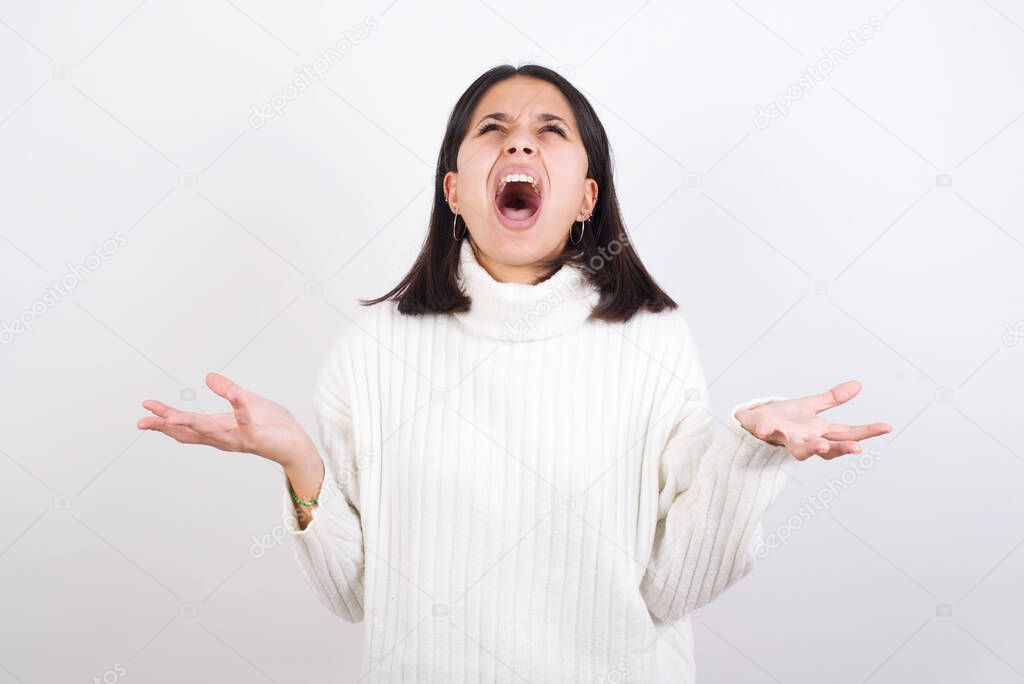 young woman crazy and mad shouting and yelling with aggressive expression and arms raised. Frustration concept.