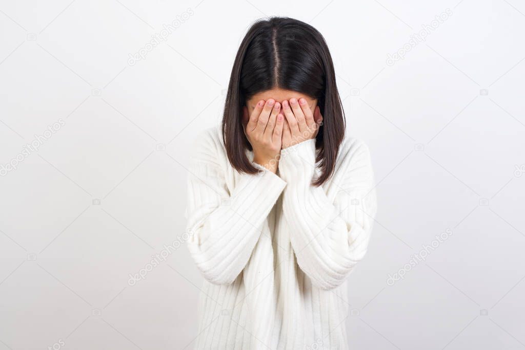 young woman covering her face with her hands, being devastated and crying. Sad concept