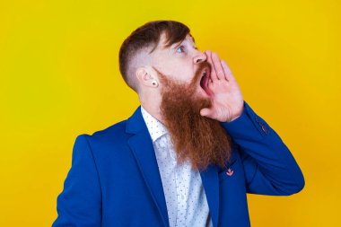 Sakallı, şok olmuş bakışlı, eli ağızda bağıran ve çığlık atan genç beyaz bir adam.