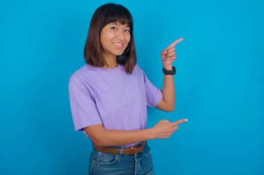 En düşük fiyatları gösteren boş bir parmak gösteren genç kadın kameraya bakıyor.