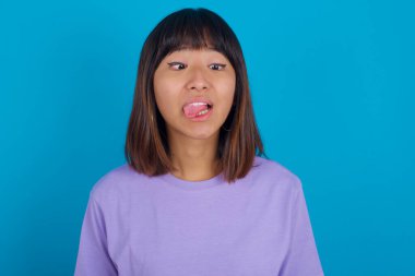young woman showing grimace face crossing eyes and showing tongue. Being funny and crazy clipart