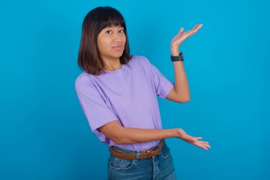 Genç bir kadın iki eliyle tuhaf bir şey gösterip 