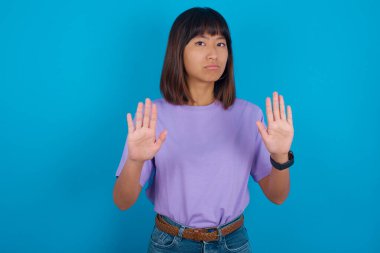 Ciddi genç bir kadın, avuç içlerini kameraya çeker, jestleri durdurur, duygularını kontrol etmek ve gergin olmamak ister.