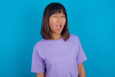 Genç bir kadın kameraya seksi bir ifadeyle bakıyor, neşeli ve mutlu bir yüzle..