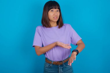 Acele eden genç kadın zamanı, sabırsızlığı, gecikme yüzünden kızgın ve kızgın olduğunu gösteriyor..