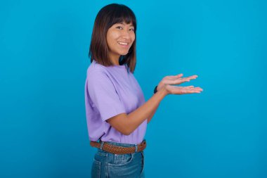 Elleri açık, fotokopi çeken, gülümseyen mutlu bir gülümseme sunan genç bir kadın.