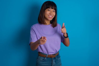 Genç bir kadın mutlu ve komik yüzüyle kamerayı işaret ediyor. İyi enerji ve titreşimler.