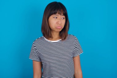 Genç kadın stresli, endişeli, yorgun ve hayal kırıklığına uğramış, gömleğini çekmiş, sorunlu görünüyor.