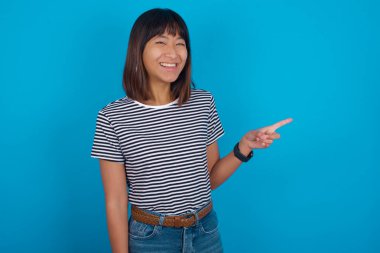 Genç bir kadın fotokopi alanını gösterir ve bir şey reklamını yapar. En iyi fiyat önerir..