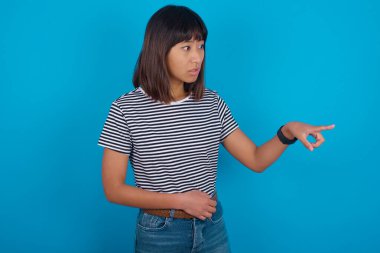 Genç bir kadın mutlu bir şekilde boş bir alanda mutlu mesut gülüyor alışveriş indirimi sunuyor, iyi haber ya da beklenmedik satıştan heyecanlanıyor..