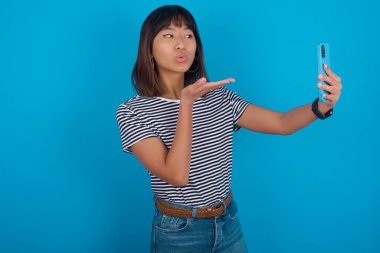 Genç bir kadın derinden şaşırıyor, akıllı telefon ekranına bakıyor, web sitesinde şok edici haberler okuyor, Omg, bu korkunç.!