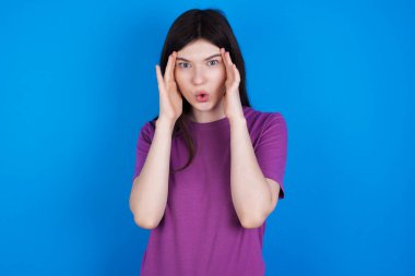 Korkmuş yüzlü genç bir kadın, elleri başının üstünde, çenesi düşmüş, müthiş bir ifadesi var. Omg kavramı