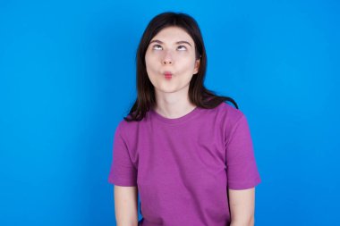 Genç bir kadın dudaklarıyla balık suratı yapıyor, çılgınca ve komik bir jest. Komik ifade.