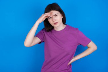 Sorunları olan genç bir kadın, endişeli ve stresli. Alnından tutuyor..