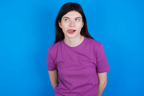 Yüzünü Ekşiten Şaşı Bakışlar Atan Dil Gösteren Genç Bir Kadın — Stok fotoğraf