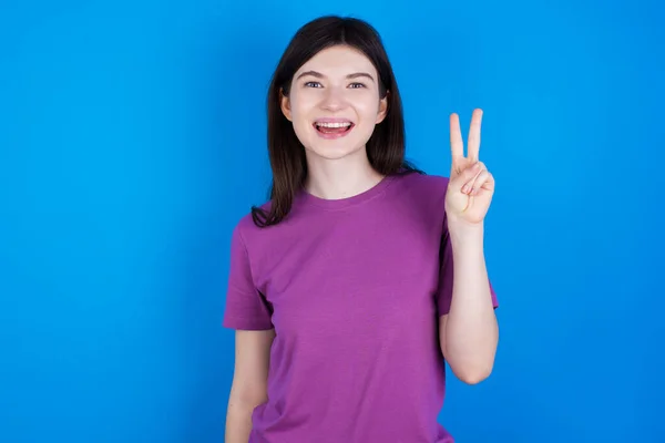 Mladá Žena Ukazuje Ukazuje Prsty Číslo Dvě Zároveň Usmívá Sebevědomě — Stock fotografie