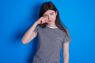 Üzgün genç kadın gözyaşlarını siliyor kasvetli bir ifadeyle strese giriyor. Olumsuz duygu