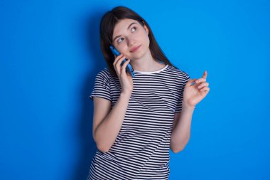 Genç bir kadın cep telefonuyla konuşuyor. Boş vakitlerini evde arkadaşlarıyla konuşarak geçiriyor..