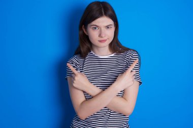 Ciddi genç bir kadın iki öğe arasında el ele tutuşup farklı tarafları işaret eder. Zor karar kavramı