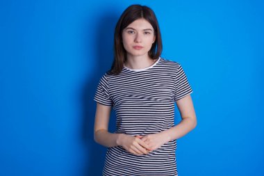 Kolları bir arada olan neşeli, kendinden emin, esmer bir kadının fotoğrafı.