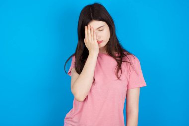 Yorgun, genç, esmer bir kadın, uykulu bir ifadeye, kasvetli bir bakışa sahip, yüzü elle kaplanmış, gözleri kapalı, yorgunluktan soluk soluğa kalmış, partiden sonra bitkinliğe kapılmış.