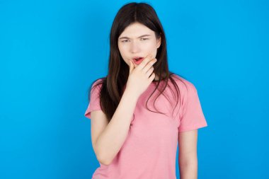 Genç esmer kadın elleri çenesinde inançsızlık, şaşkınlık ve şaşkınlık içinde bakıyor.