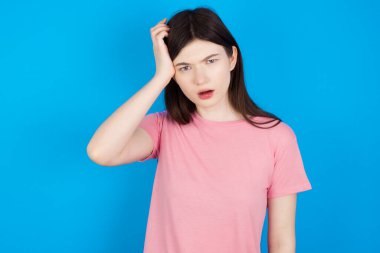 Utangaç, genç, esmer bir kadın, şok olmuş bir ifadeyle, büyük bir şaşkınlık içinde, bilmece gibi, kapalı mekanda poz veriyor.