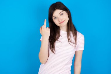 young brunette woman shows middle finger bad sign asks not to bother. Provocation and rude attitude.