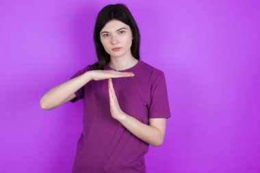 Genç, esmer bir kadın bir jest yaparken üzülüyor, durması gerekiyor, çok çalıştıktan sonra dinlenmek istiyor, el işaretini kırıyor.