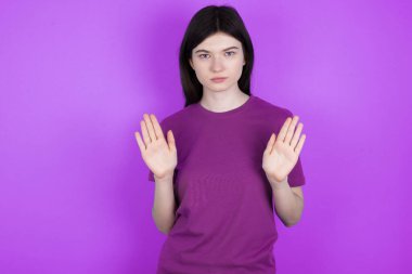 Ciddi genç esmer kadın, avuç içlerini kameraya çeker, jestleri durdurur, duygularını kontrol etmek ve gergin olmamak ister.