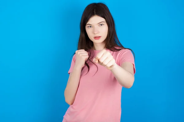 young brunette woman Punching fist to fight, aggressive and angry attack, threat and violence