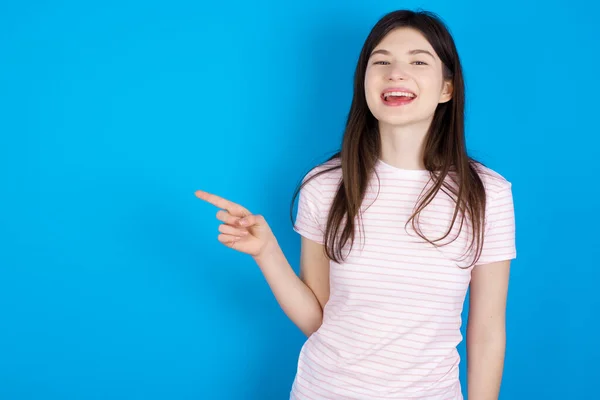 Young Brunette Woman Laughs Happily Points Away Blank Space Demonstrates — Stok fotoğraf