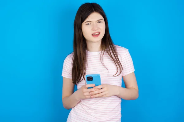 Photo Astonished Crazy Young Brunette Woman Hold Smartphone Dislike Feedback — Fotografia de Stock