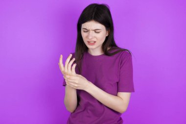 Genç esmer kadın ellerinde ve parmaklarında acı çekiyor, eklem iltihabı.