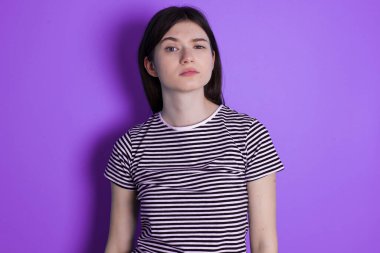 Displeased young brunette woman frowns face feels unhappy has some problems. Negative emotions and feelings concept