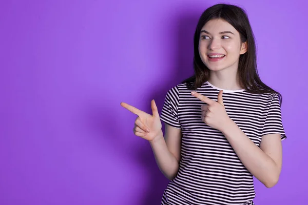 Optimistic Young Brunette Woman Points Both Hands Looking Empty Space — ストック写真