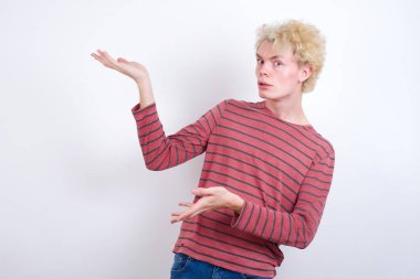 Genç adam iki eliyle tuhaf bir şey gösterip 