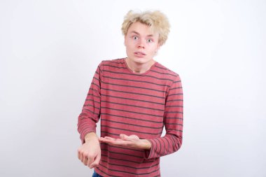 Genç sarışın adam acele edip saati, sabırsızlığı ve gecikmeye kızmayı işaret ediyor..