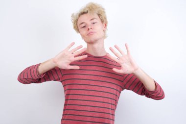 Genç sarışın adam kendini beğenmiş ve mutlu bir şekilde gülümserken on numarayı işaret ediyor..